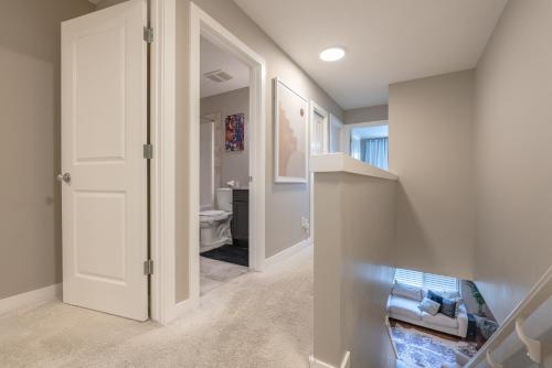 un couloir avec une porte menant à une salle de bains. dans l'établissement Modern 3 Bedroom Home & Office & Media Room, à Cochrane