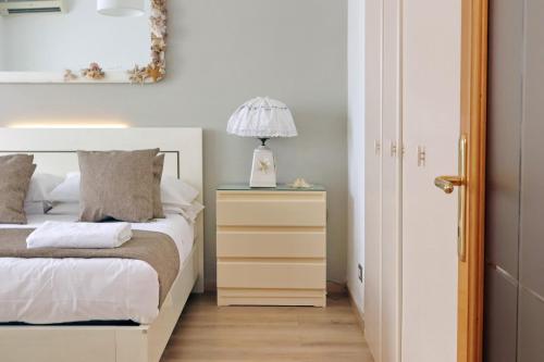 a bedroom with a bed and a lamp on a night stand at 4BNB - Luxury Stelvio Penthouse in Fonte Nuova