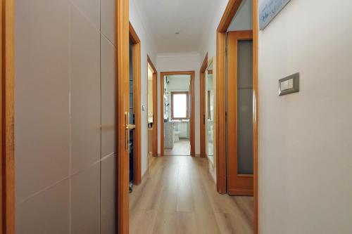 a hallway with wooden floors and doors in a house at 4BNB - Luxury Stelvio Penthouse in Fonte Nuova