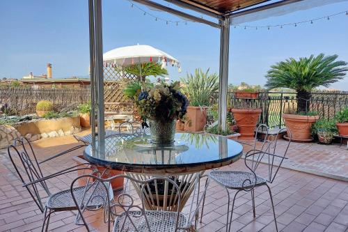 a patio with a table with chairs and an umbrella at 4BNB - Luxury Stelvio Penthouse in Fonte Nuova
