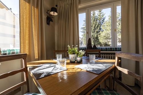 una sala da pranzo con tavolo in legno e finestra di Aparthotel Claviere a Claviere