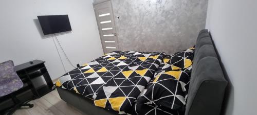 a bedroom with a bed with black and yellow at ILONA APARTAMENT 3 camere in Râmnicu Vâlcea