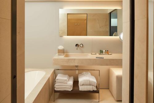 a bathroom with a sink and a tub and a mirror at Hilton Lake Como in Como