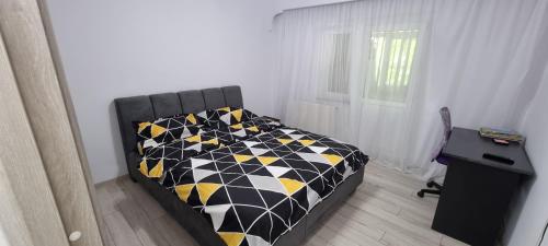 a bedroom with a bed with a black and yellow at ILONA APARTAMENT 3 camere in Râmnicu Vâlcea