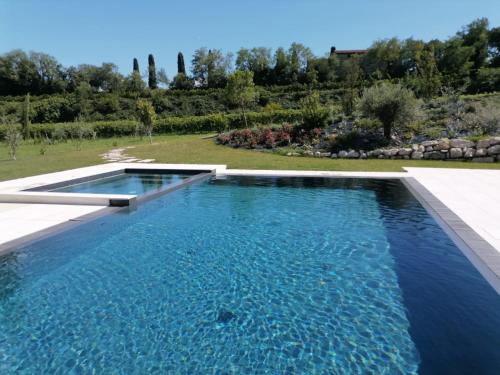 a swimming pool with blue water in a yard at Relais Ca' Morenica in Valeggio sul Mincio