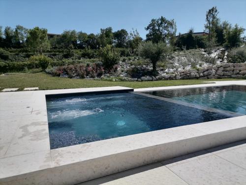 a swimming pool in a yard with a landscaping at Relais Ca' Morenica in Valeggio sul Mincio