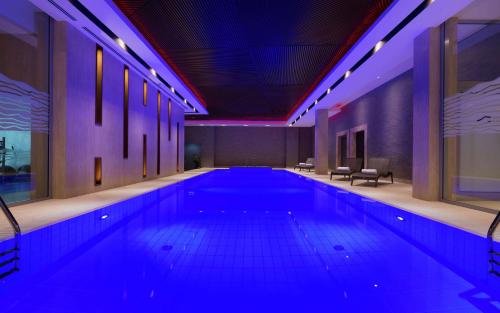 una gran piscina en un edificio con luces azules en DoubleTree By Hilton Moscow - Vnukovo Airport Hotel, en Vnukovo
