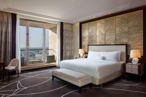 - une chambre avec un grand lit et une grande fenêtre dans l'établissement Waldorf Astoria Berlin, à Berlin