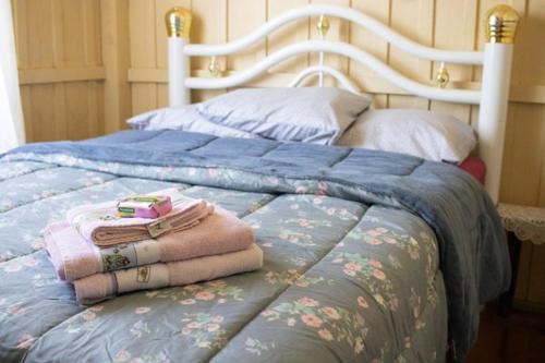 ein Bett mit einigen Decken und Kissen darauf in der Unterkunft Gasthaus Heimat in Rio Forcação