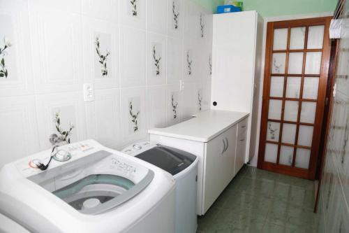 a bathroom with a washing machine in a room at Chalet Rustico da Elena com Sauna y Jacuzzi Unicep in São Carlos