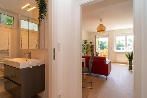 a kitchen and living room with a sink and a couch at Balcony Oasis Wilhelminenberg in Vienna