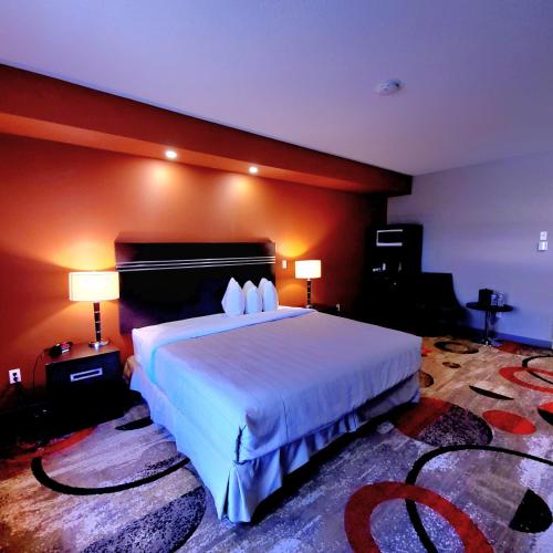 a bedroom with a large white bed with two lamps at Wabasca Inn in Wabasca