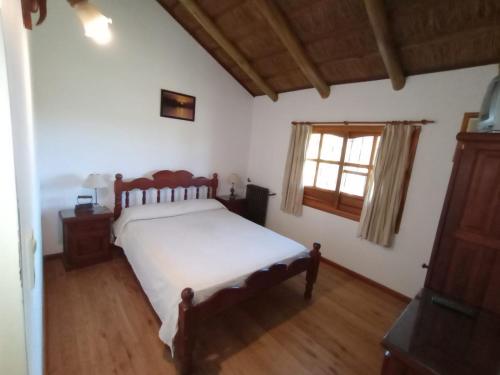 Un dormitorio con una cama grande y una ventana en Cabañas del Paraiso en Colón