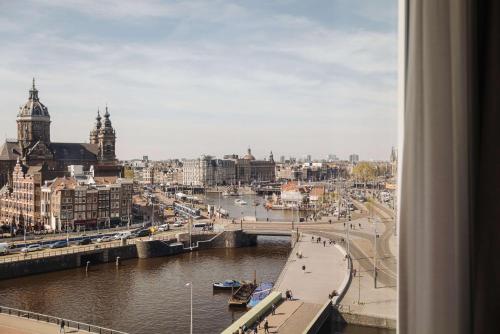 Blick auf eine Stadt mit Fluss und Gebäuden in der Unterkunft DoubleTree by Hilton Amsterdam Centraal Station in Amsterdam