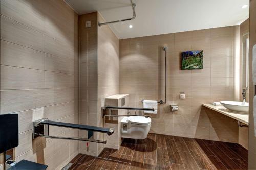 a bathroom with a toilet and a sink at Hilton Garden Inn Davos in Davos