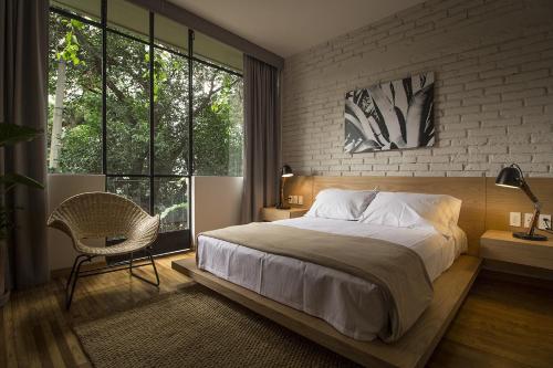 a bedroom with a large bed and a chair at Casa Alfredo in Mexico City