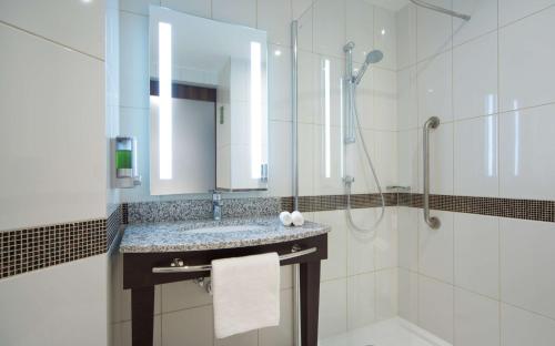 a bathroom with a sink and a shower at Hampton by Hilton Saint-Petersburg ExpoForum in Saint Petersburg