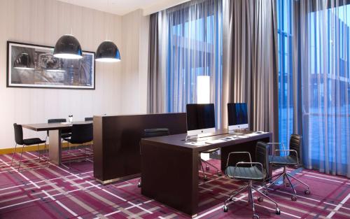 an office with two desks and chairs and windows at Hampton by Hilton Saint-Petersburg ExpoForum in Saint Petersburg