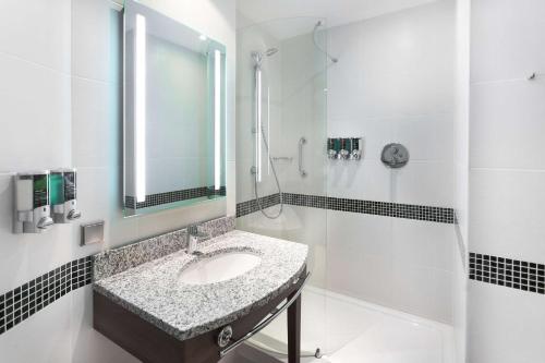 Baño blanco con lavabo y espejo en Hampton by Hilton Samara en Samara