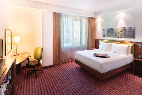 a hotel room with a bed and a desk and a television at Hampton by Hilton Samara in Samara