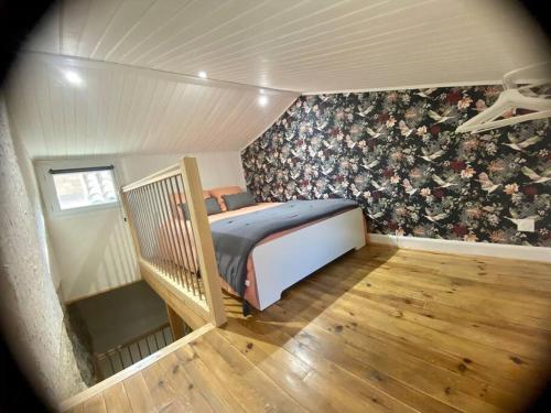 - une chambre avec un lit orné d'un mur fleuri dans l'établissement La maison d Evahlia, à Creissels