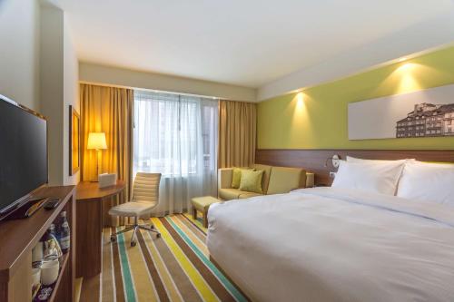 a hotel room with a large bed and a television at Hampton by Hilton Warsaw City Centre in Warsaw
