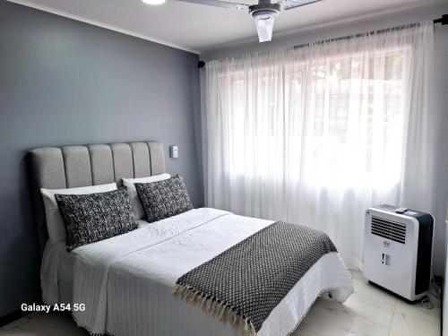 a bedroom with a large bed and a window at Casa Victoria CR in San Isidro