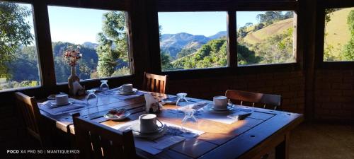 a dining room with a table with a view of mountains at Pousada Serra Vista in Gonçalves