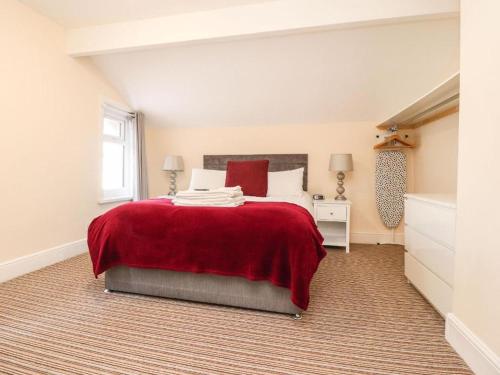 a bedroom with a large bed with a red blanket at The Oxfordshire in Blackpool