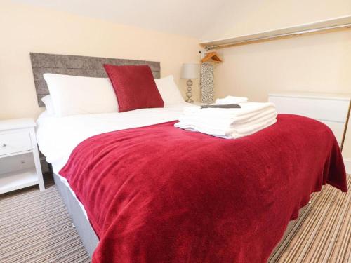a bedroom with a large bed with a red blanket at The Oxfordshire in Blackpool