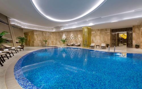 a large swimming pool in a hotel room at Hilton Astana in Astana