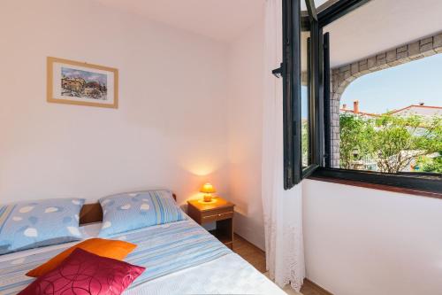 Schlafzimmer mit einem Bett und einem Fenster in der Unterkunft Andela Apartment in Pula