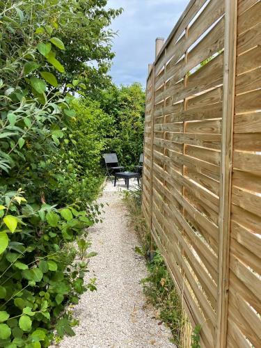 una valla y un banco en un camino de grava junto a una valla en Beau studio équipé - Calme et confortable en Bourg-en-Bresse