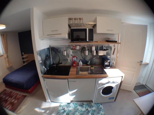a small kitchen with a stove and a microwave at Beau studio équipé - Calme et confortable in Bourg-en-Bresse