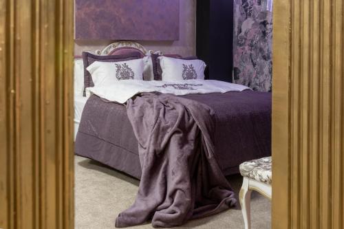 a bedroom with a bed with a blanket on it at Aparthotel AA in Sarajevo