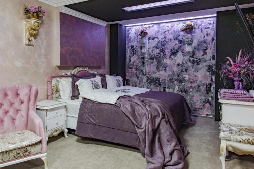 a purple bedroom with a bed and a purple wall at Aparthotel AA in Sarajevo