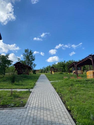 a brick path in a field with a blue sky at Pensiunea Agroturistica Casa Tarta in Livada