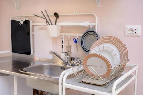 a dish rack with dishes on it next to a sink at La Casa del Vino in Parma