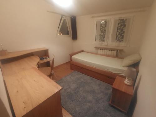 a small bedroom with a bed and a desk at La maison sous le Château in Tallard