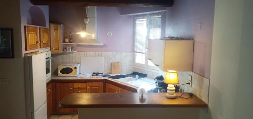 a kitchen with a table with a lamp on it at La maison sous le Château in Tallard