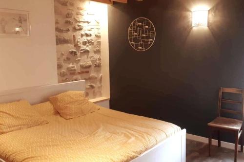 - une chambre avec un lit, une lampe et une chaise dans l'établissement La Manufacture d'épaulettes, à Prades