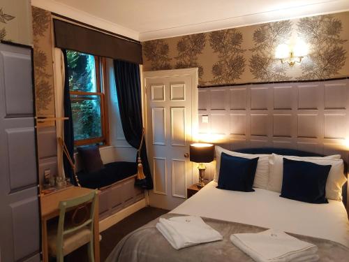 a bedroom with a bed and a desk and a window at East Claremont Guest House in Edinburgh