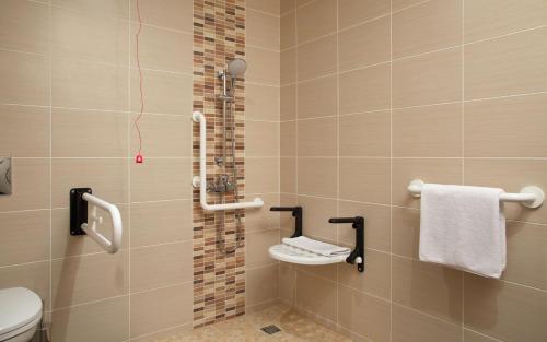 a bathroom with a shower with a toilet and towels at Hilton Garden Inn Moscow New Riga in Istra