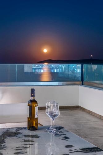 a bottle of wine and a wine glass on a table at NOS Suites in Ermoupoli
