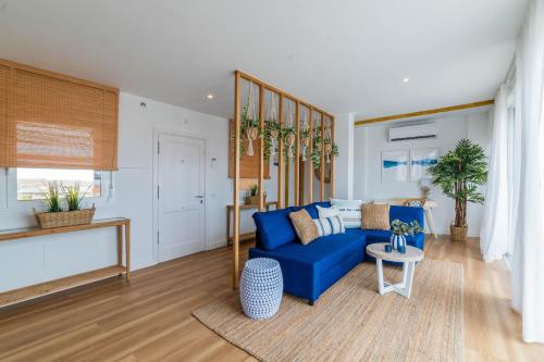 a living room with a blue couch and a table at Ático Cholas by the Beach in San Miguel de Abona