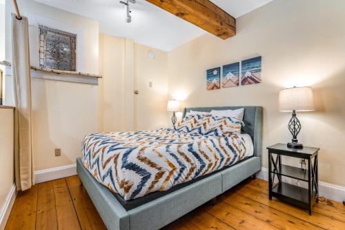 sypialnia z łóżkiem i lampką na stole w obiekcie Stowe Mountain Road Escape w mieście Stowe