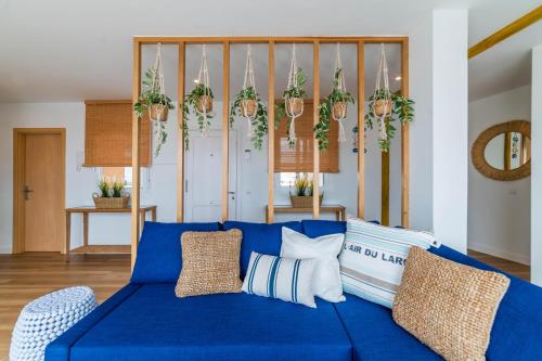 un divano blu in soggiorno con piante in vaso di Ático Cholas by the Beach a San Miguel de Abona