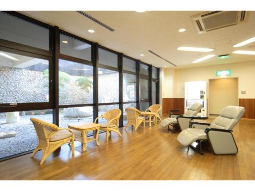une salle d'attente avec des chaises, des tables et des fenêtres dans l'établissement Hotel Bellreef Otsuki - Vacation STAY 43762v, à Otsuki