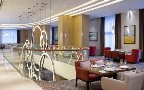 a dining room with a glass table and chairs at DoubleTree by Hilton Almaty in Almaty