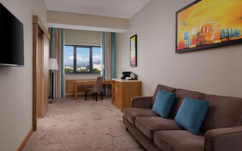 a living room with a couch and a table at DoubleTree by Hilton Almaty in Almaty